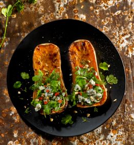 calabazas al horno servidas con queso y hierbas