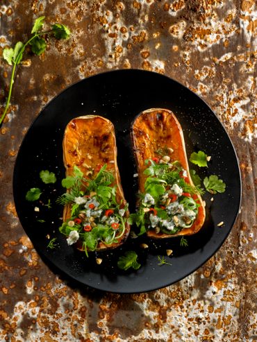 calabazas al horno servidas con queso y hierbas