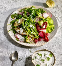 ensalada variada servida con salsa de yogurt