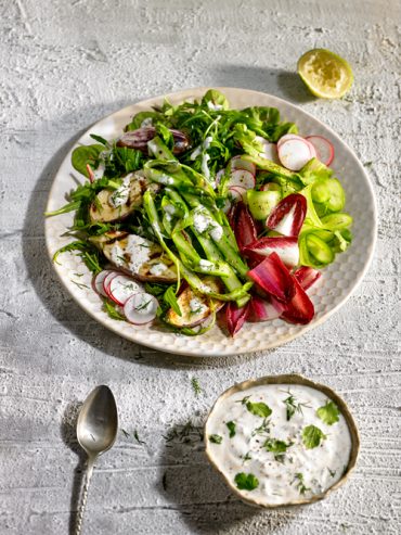 ensalada variada servida con salsa de yogurt